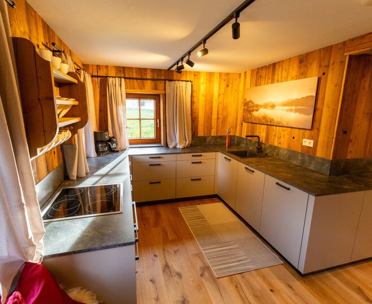 The Bed and Breakfast kitchen features a U-shaped kitchen unit, hob, sink, coffee machine, and wooden walls.