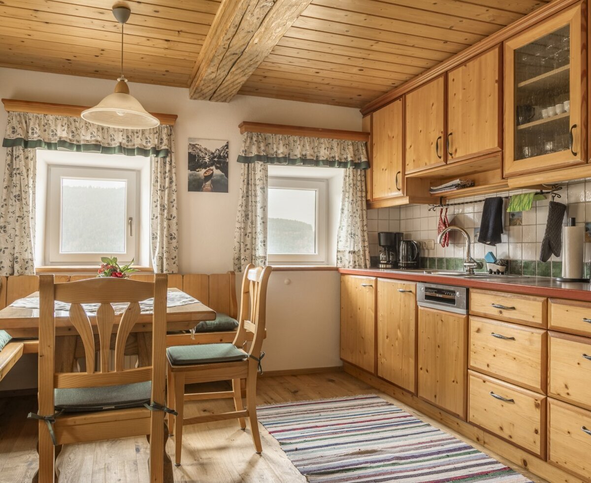 Kitchen and dining area in the Bed and Breakfast, featuring wooden furnishings, a kitchenette, and a dining table with a corner bench.