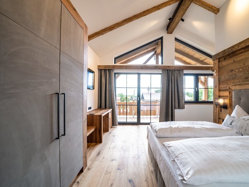 Double bedroom in the Farm House with a wardrobe, satellite TV, balcony access, and wooden beamed ceilings.