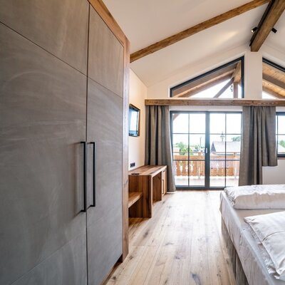 Double bedroom in the Farm House with a wardrobe, satellite TV, balcony access, and wooden beamed ceilings.