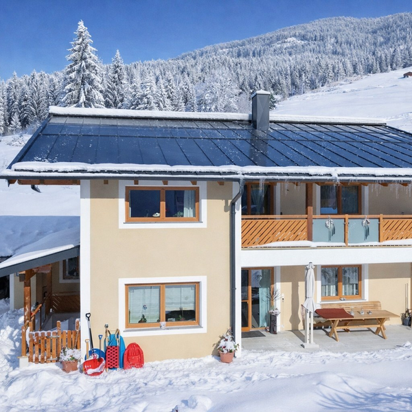 Exterior view  in winter with a snow-covered landscape, an upstairs balcony, and a ground-floor terrace.