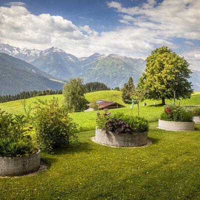 The bed and breakfast's manicured garden featuring circular raised beds and scenic views of the surrounding mountains.