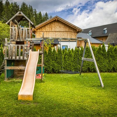 The Farm House garden includes a children's playground with a slide and a swing set.