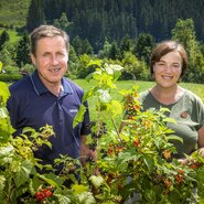 The hosts of the farmhouse in their garden, featuring fresh red and black currants.