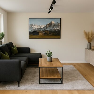 The living room of the Bed and Breakfast features a dark L-shaped sofa, a wooden coffee table, and a television.