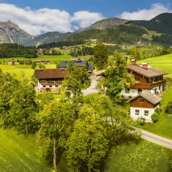 The Bed and Breakfast, featuring traditional buildings, surrounded by green meadows and mountains.