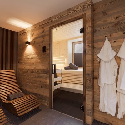 Sauna and relaxation area in the Bed and Breakfast with wooden lounge chairs and bathrobes.