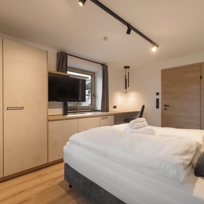 double bed, wardrobe, desk, and television.