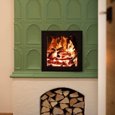 Green tiled stove with a burning fire.