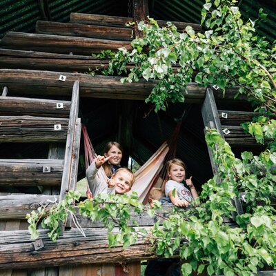 The farmhouse's rustic playhouse offers a fun and inviting space for children to play in the fresh air.