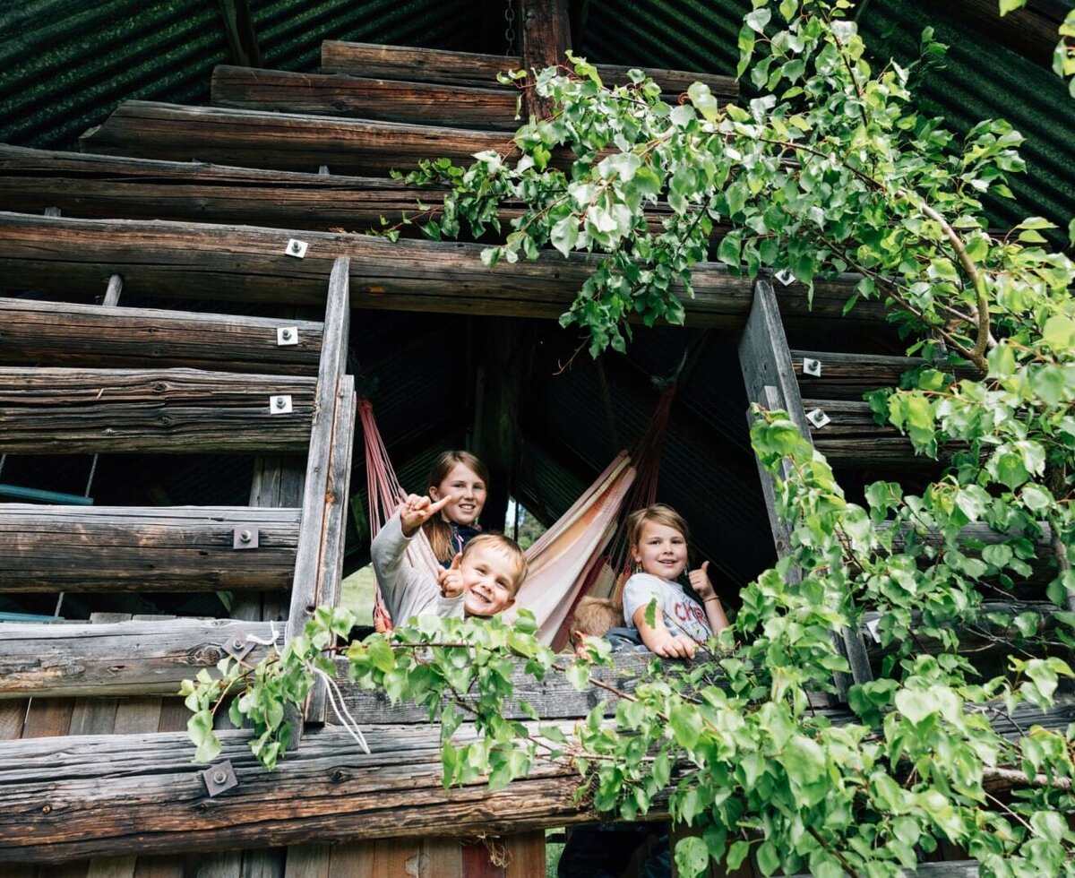 The farmhouse's rustic playhouse offers a fun and inviting space for children to play in the fresh air.