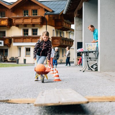 A lively play area at the farmhouse, where children can enjoy a fun obstacle course with toy wheelbarrows and cones.