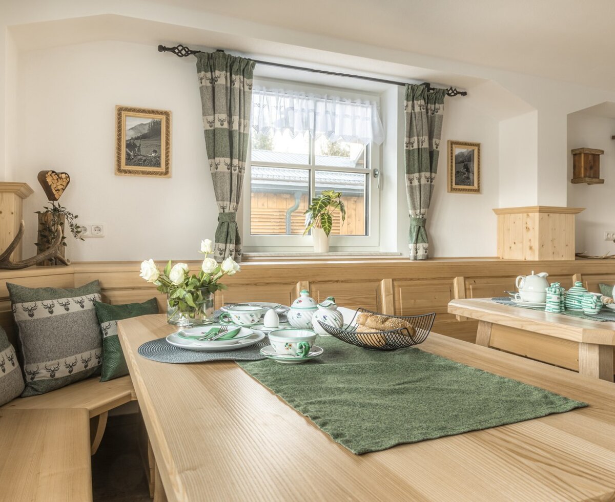 The dining area, featuring wooden tables, benches, and traditional decor.