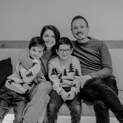 A family with two children sitting on a bench in the farmhouse.