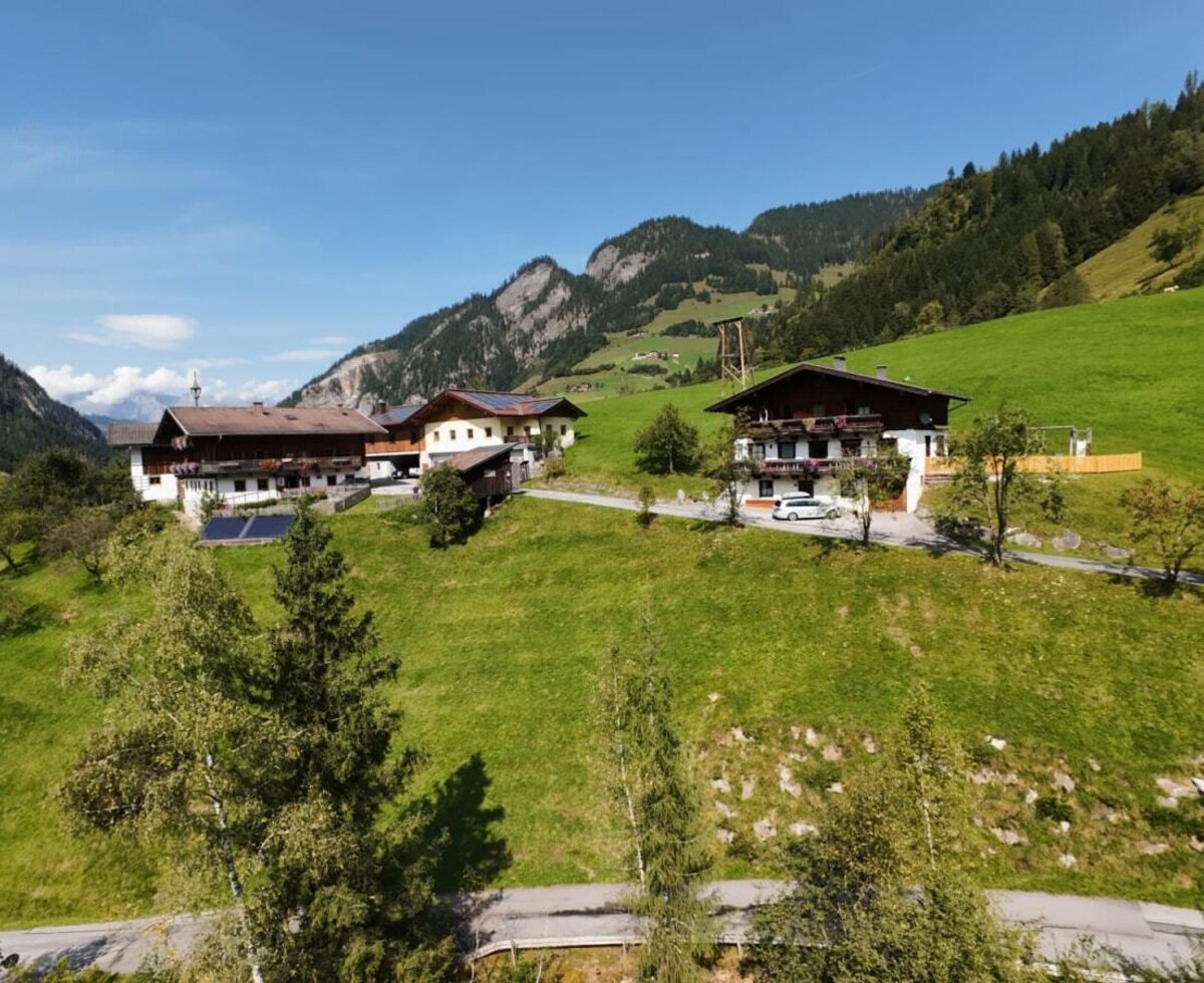 The Lambachhof is located on a slight hill, surrounded by mountains and green meadows.