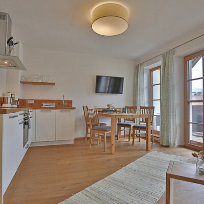 Fully equipped kitchen and dining area with a TV in the apartment.
