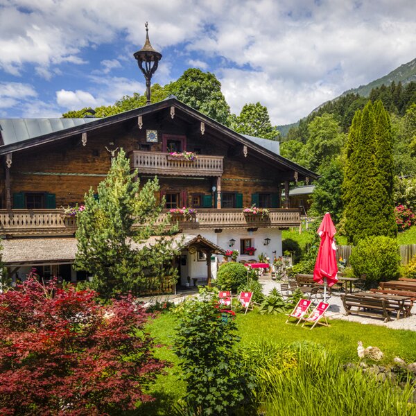 The farmhouse's inviting garden featuring a lush lawn, outdoor seating areas, and vibrant greenery.