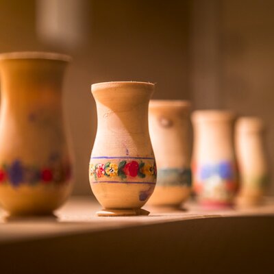 Hand-painted wooden decorative pieces with floral patterns, displayed inside the farmhouse.