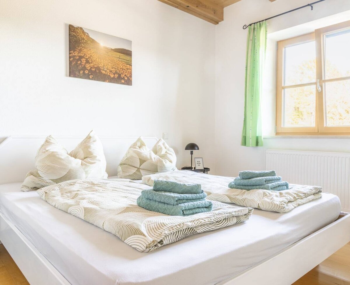A cozy double bedroom at the farmhouse with an inviting double bed, fresh towels, and bright, natural light.