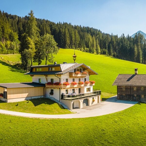 The inviting Peterlehen farmhouse in a quiet, sunny hillside location, surrounded by green meadows and forests.