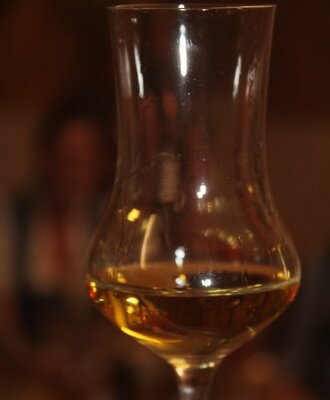 A traditional schnapps glass with an amber beverage, available at the Farm House.