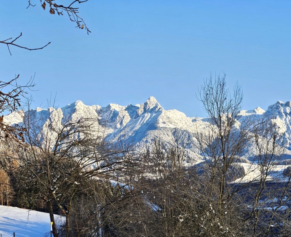 View from the farmhouse of the snow-covered mountains and the winter landscape.