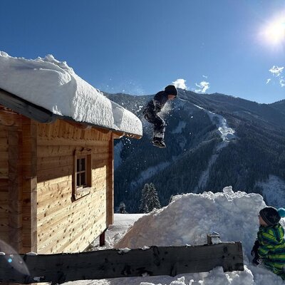 Playful winter fun at the farmhouse, set against a scenic backdrop of snow-covered mountains.