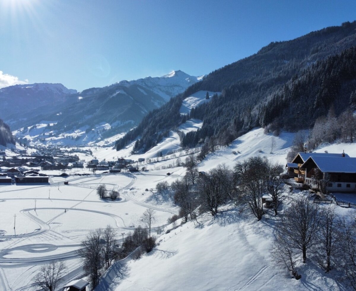 View of the farmhouse, the snowy valley, and the surrounding mountains.