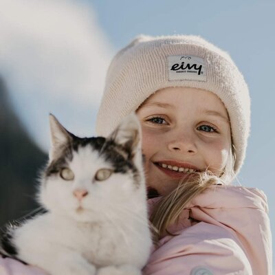 A smiling child holds a cat, a common sight at the farmhouse.