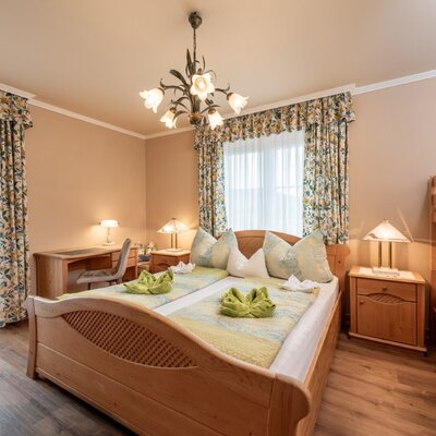 Bedroom in the farm house featuring two single beds, a bunk bed, a desk, and balcony access.