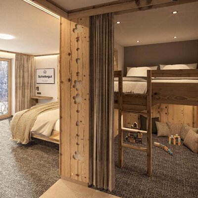 Bedroom in the farmhouse featuring a double bed, a bunk bed, and a window with a view of the snowy landscape.