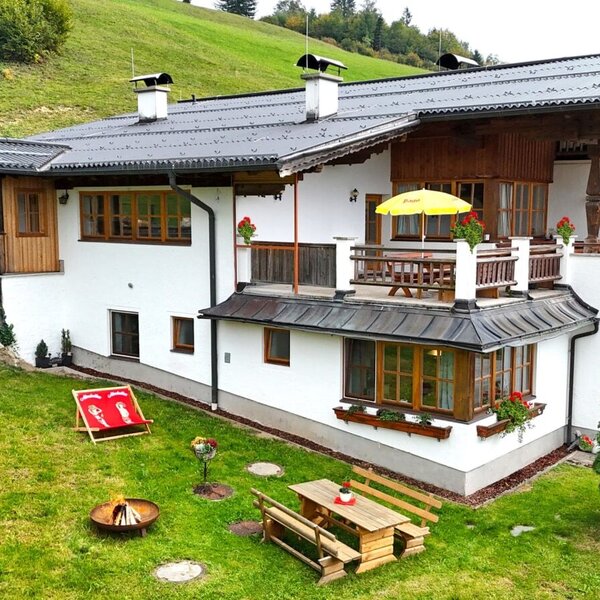 The charming Ferienwohnung featuring a well-kept garden with outdoor seating, a fire pit, and an inviting balcony.