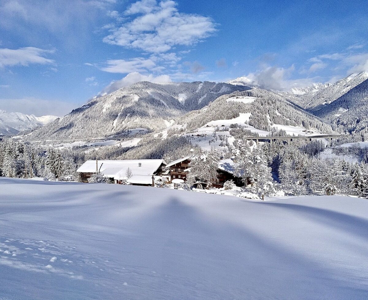 Winter landscape with snow-covered mountains and trees.
