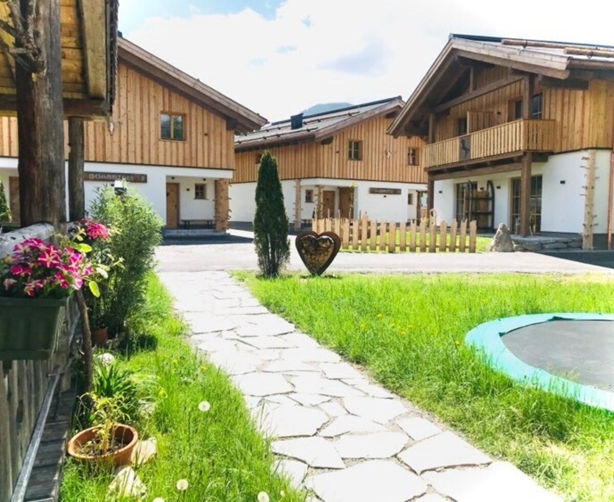 The farmhouses, featuring a lawn with a trampoline and some units with balconies.