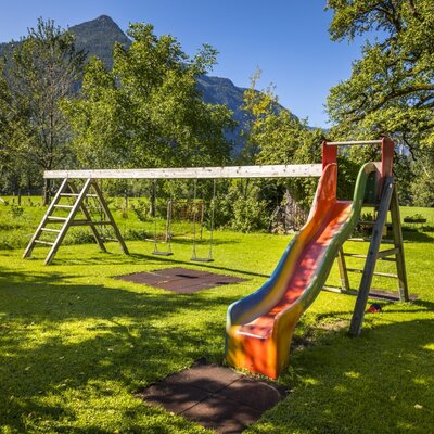 The Farm House provides an outdoor children's playground featuring a swing set and a slide.