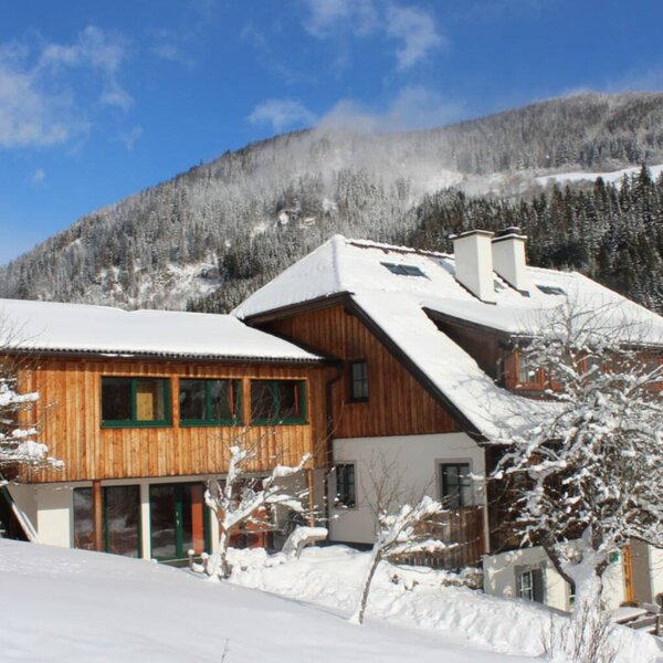 The exterior of the Farm House, featuring snow-covered roofs and wooden facades, nestled in a winter landscape with snow-capped mountains. The exterior of the Farm House, featuring snow-covered roofs and wooden facades, nestled in a winter landscape with snow-capped mountains.