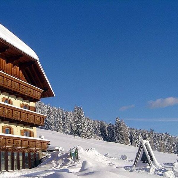 The Farm House exterior featuring multiple wooden balconies, a snow-covered outdoor area with a slide, and views of the surrounding winter mountains and trees. The Farm House exterior featuring multiple wooden balconies, a snow-covered outdoor area with a slide, and views of the surrounding winter mountains and trees.