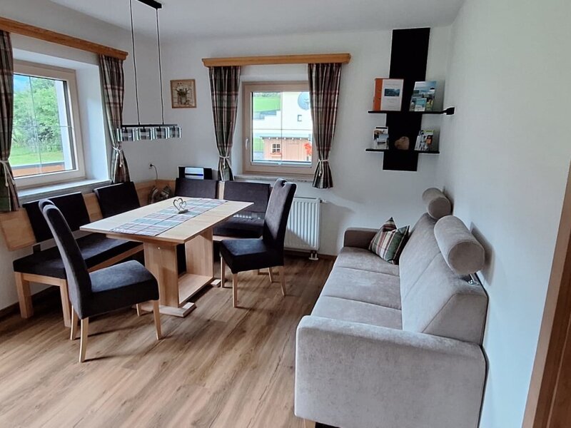 The inviting living and dining area of the holiday apartment featuring a cozy dining nook and a comfortable sofa.