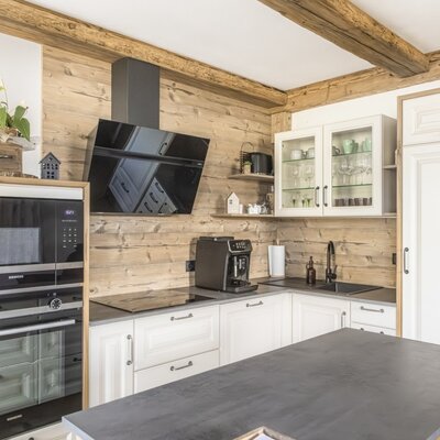 Fully equipped kitchen in the Ferienwohnung featuring an oven, microwave, induction hob, coffee machine, and kitchen island.