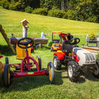 The apartment's inviting play area, featuring pedal tractors on a lush green lawn.