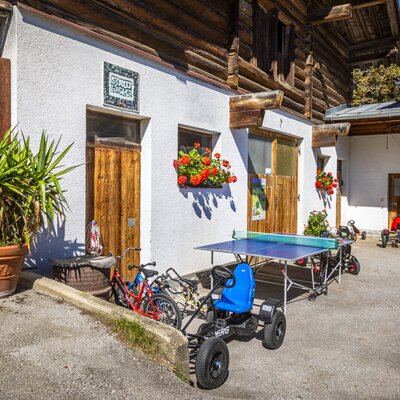 The Farm House features an outdoor area with a ping-pong table, children's pedal cars, and bicycles for guest recreation.