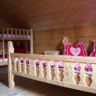 Double bed and bunk bed in one of the solid wood bedrooms at the farmhouse.