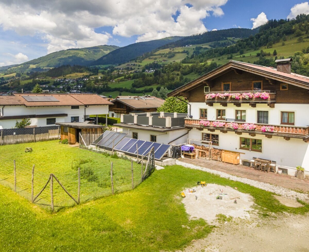 The inviting building housing the apartment features a spacious garden, a children's sandbox, and scenic views of the surrounding mountains.