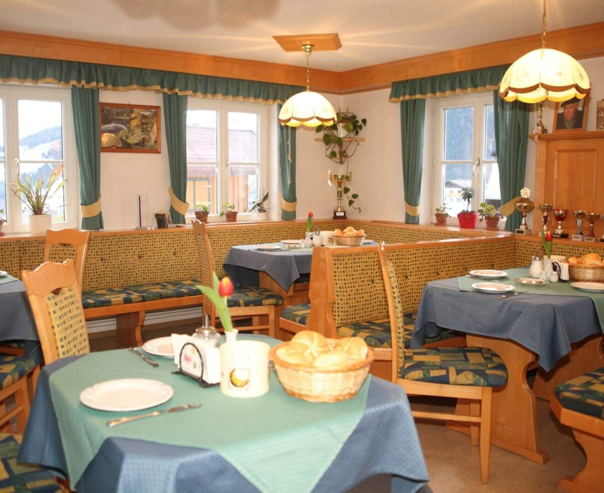 The farmhouse's cozy breakfast room featuring traditional wooden seating areas and warm, inviting lighting.