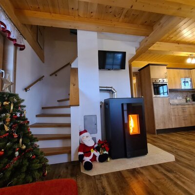 The farmhouse features an open-plan living and kitchen area, complete with a modern stove, television, and a staircase.