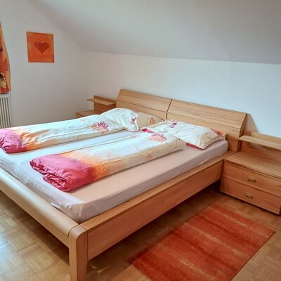 Bedroom in the Farm House with a double bed, two wooden bedside tables, and a window.