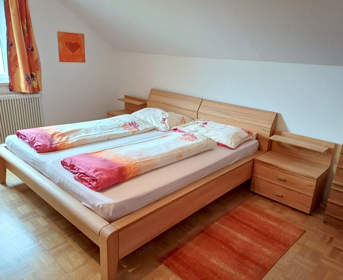 Bedroom in the Farm House with a double bed, two wooden bedside tables, and a window.