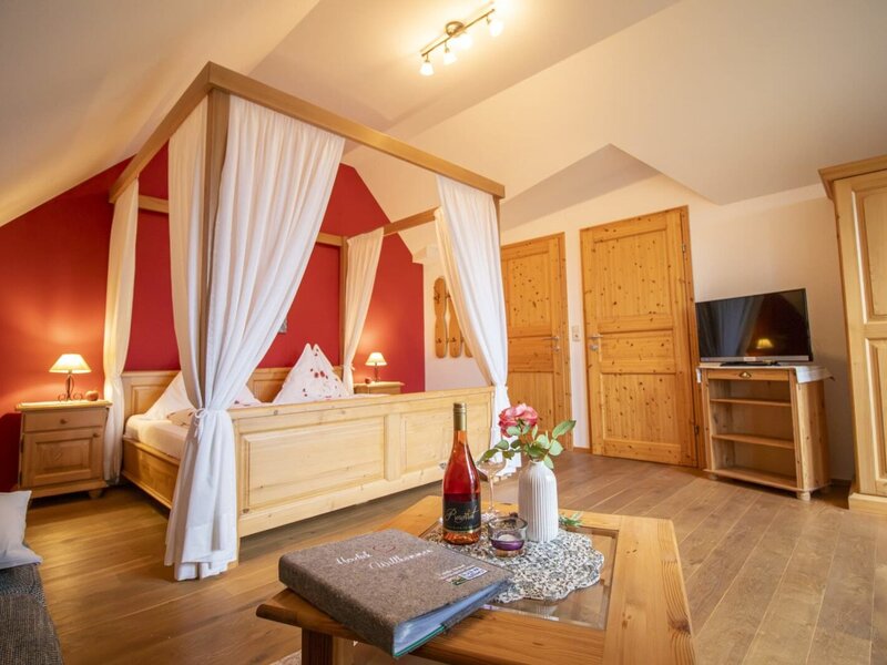 A cozy bedroom in the farmhouse featuring an inviting wooden canopy bed, warm lighting, and rustic wooden furniture.
