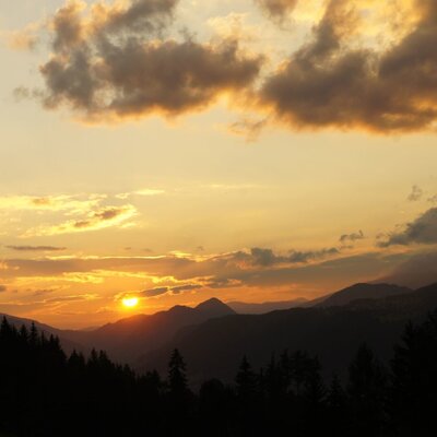 View of the sunset over mountains and forests from the Farm House.