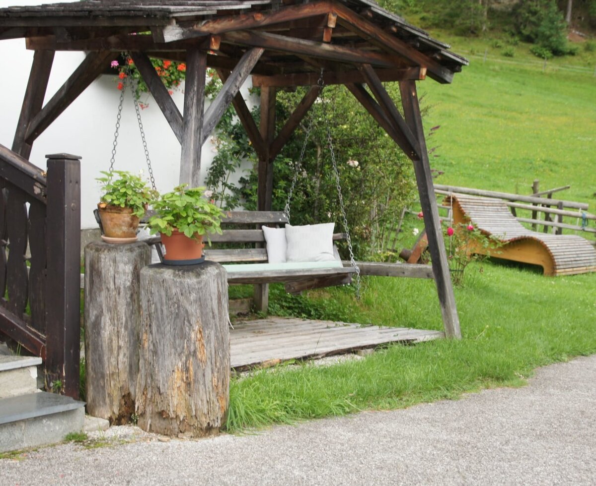 Swing bench and sun lounger in the garden area of the farmhouse.